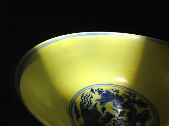 A Chinese yellow ground dragon and phoenix bowl, Xuande six character mark and possibly of the period, 19.5cm, museum restoration, sc